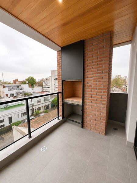 Living comedor y balcón con parrilla